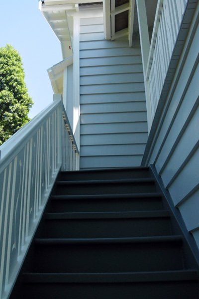 Dark steps with white handrails leading up to the entrance of home