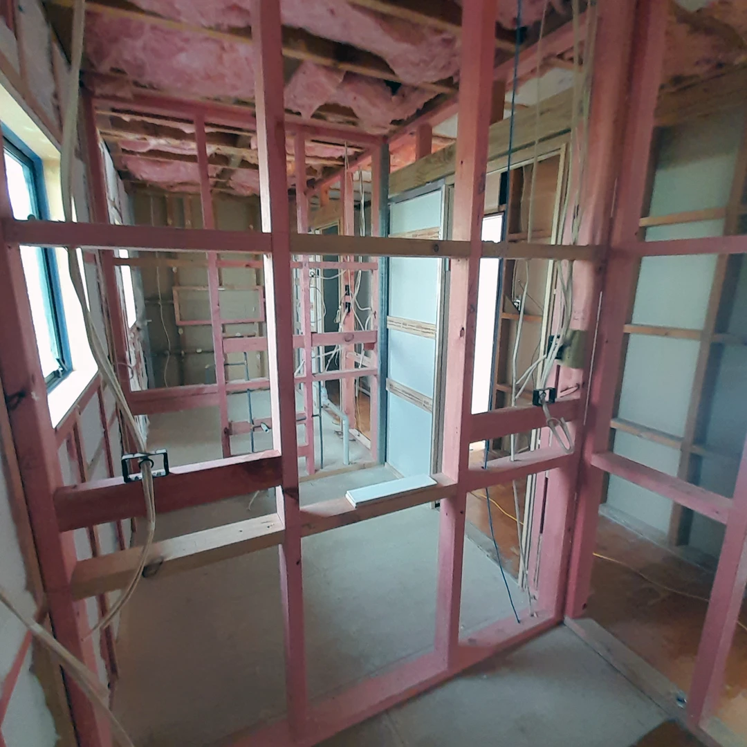 Inside a construction site, a view of a building's interior with vibrant pink walls.