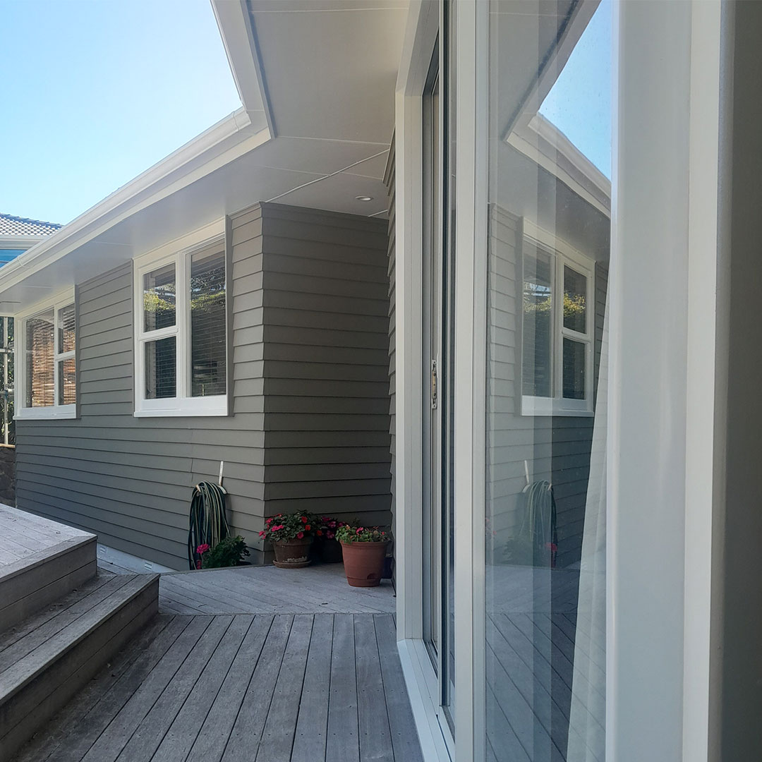 A large window with grey weatherboards and white trim